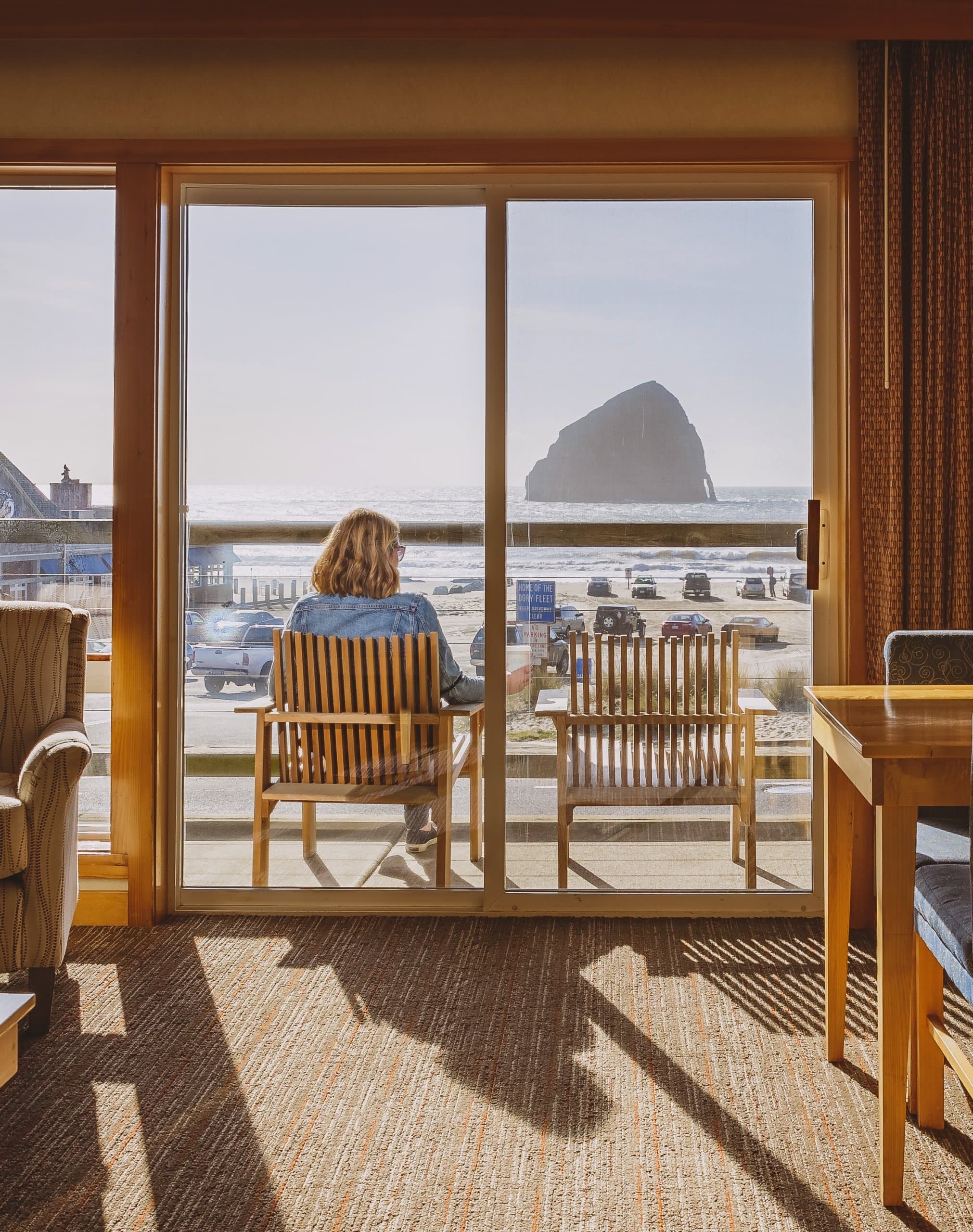 Woman sitting in her balcony chair overlooking the beach at the Inn at Cape Kiwanda