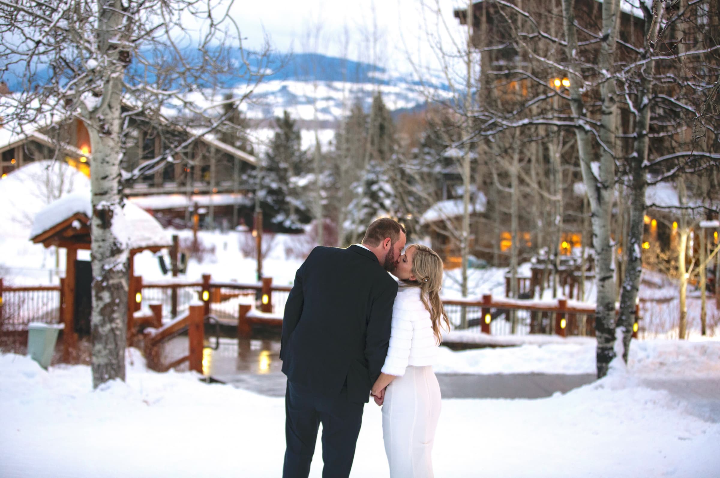 Bride and Groom sharing a kiss in front of Teton Village