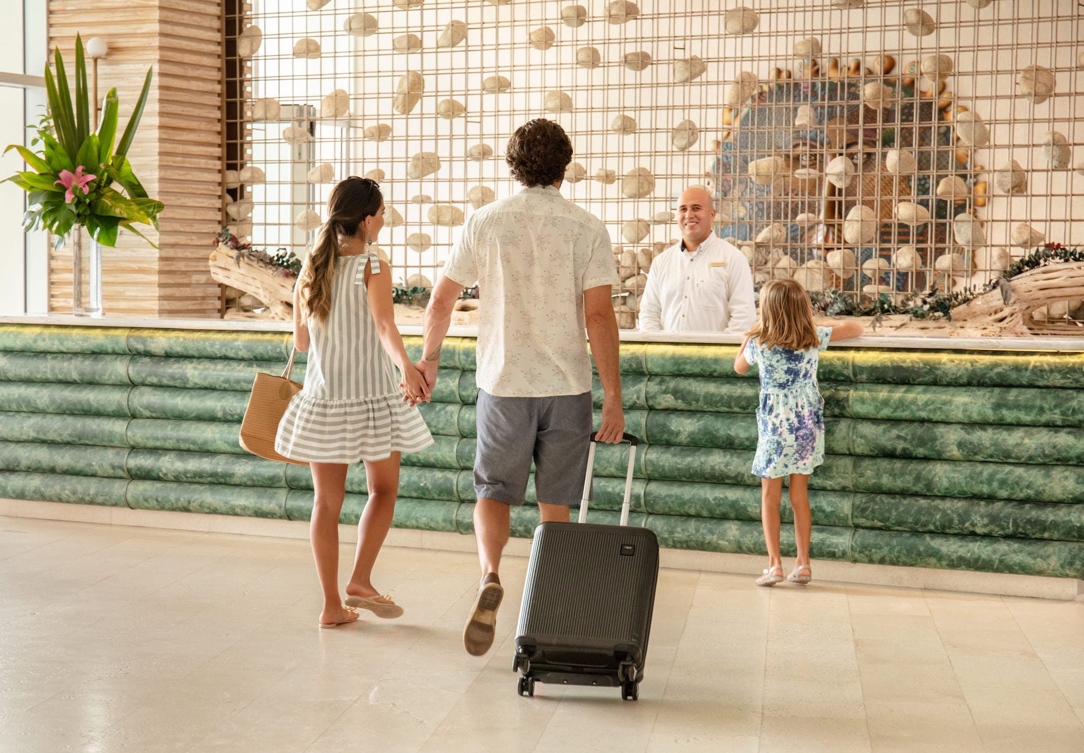 A family checking in at the front desk of a Noble House property