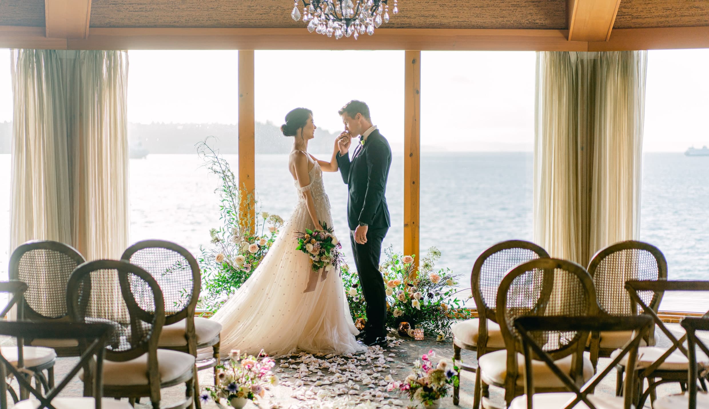Groom kissing bride's hand in The Edgewater hotel in Seattle