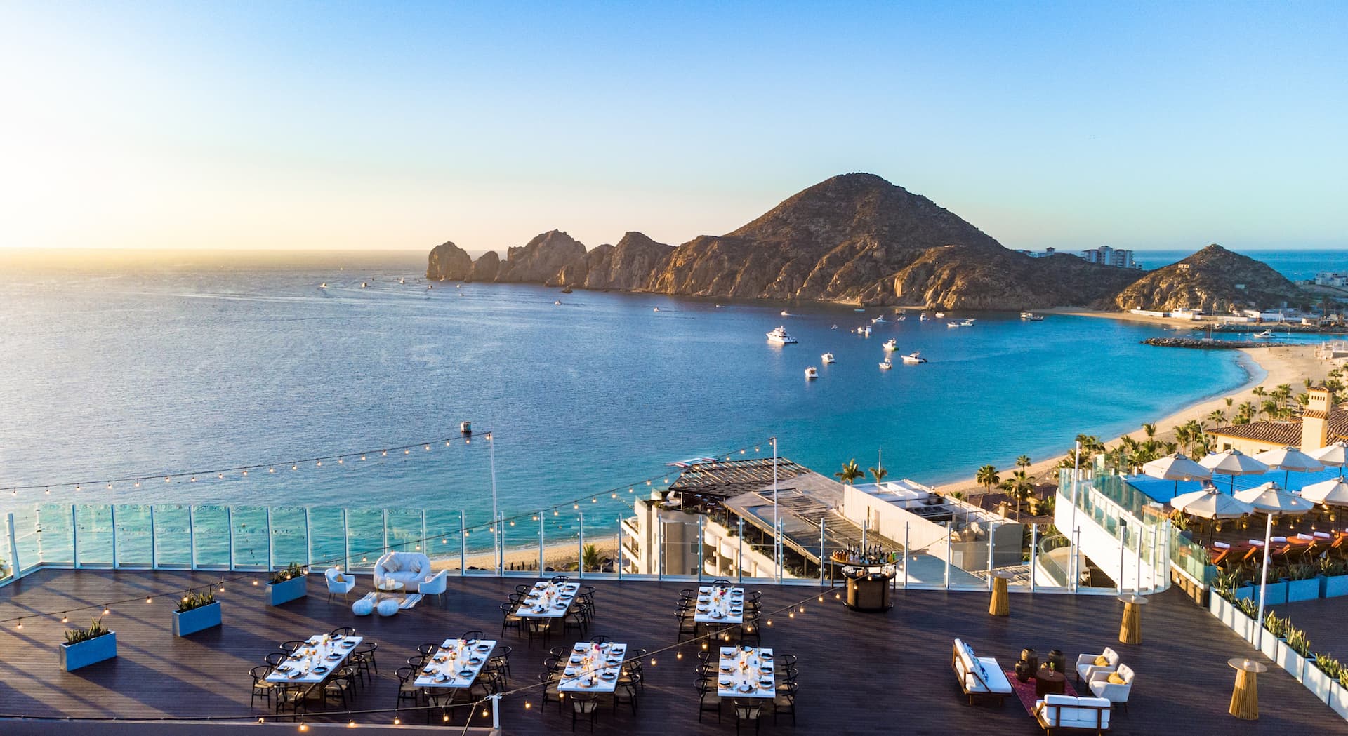 Rooftop dining and seating area near the ocean at a Noble House Hotels & Resorts property