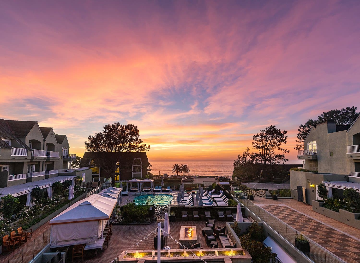 Pool and outdoor seating area with view of the water at a Noble House Hotels & Resorts property