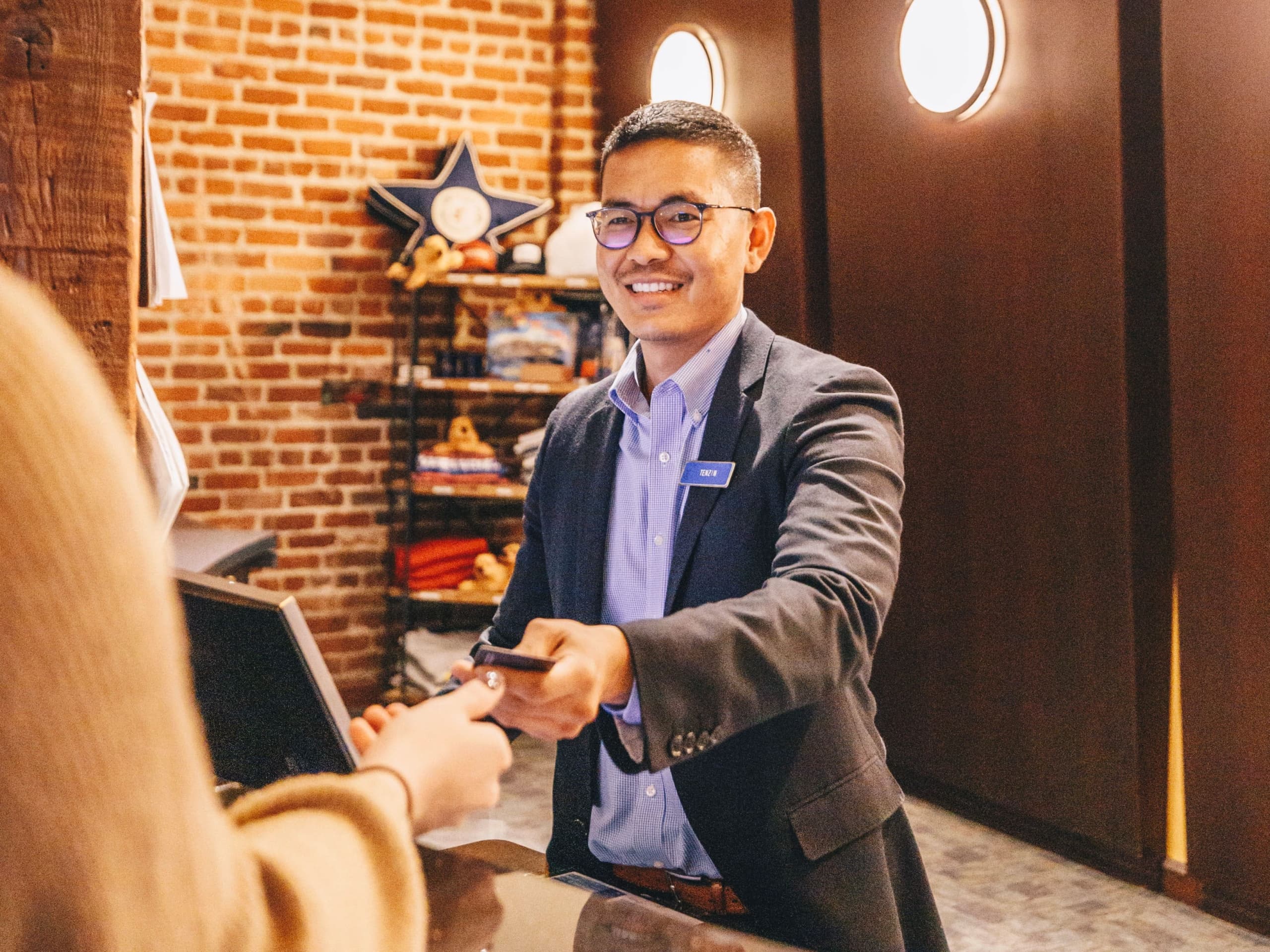 A happy Argonaut employee handing a guest a key card